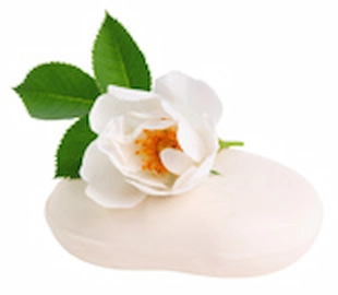 白い花が添えられた石鹸の写真
