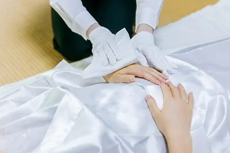 故人様の左手を拭き清める納棺師の手元の写真