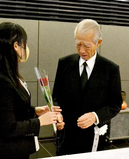 葬儀事例のサムネイル画像 セレモニー目黒にてお手向するバラを受け取るご主人