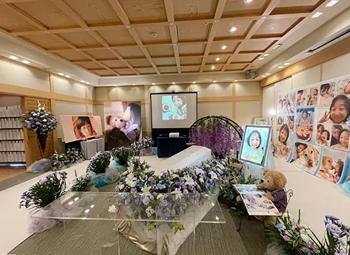 葬儀事例「私の娘でありがとう」のギャラリー画像2枚目 笑顔いっぱいのお写真とお花に囲まれたお棺