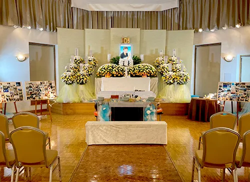 葬儀事例「走り続けたママ」のギャラリー画像1枚目 たくさんのご供花の中笑顔で微笑む故人の遺影と祭壇