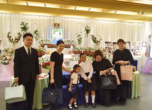 葬儀事例「最強のおばあちゃん」のギャラリー画像1枚目 家族と親族様でおばあちゃんの写真の前で写真撮影