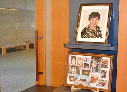 葬儀事例「おばあちゃんへの恩返し」のギャラリー画像2枚目 式場入り口に並ぶお祖母様のたくさんのお写真