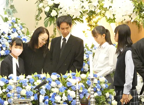 葬儀事例「父から学んだこと」のギャラリー画像2枚目 テーマカラーのお花に囲まれご家族揃ってお見送り